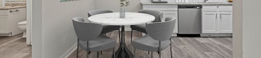 a dining area with a table and chairs and a kitchen in the background