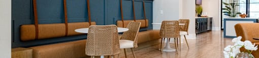 A room with a blue wall and brown chairs.