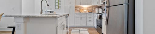 A modern kitchen with a large island and stainless steel appliances.