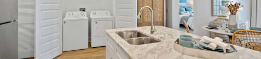 A modern kitchen with a marble countertop and stainless steel appliances.