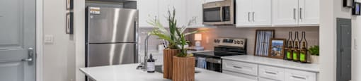 A modern kitchen with white cabinets and a large island.