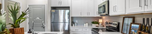 A modern kitchen with white cabinets and stainless steel appliances.