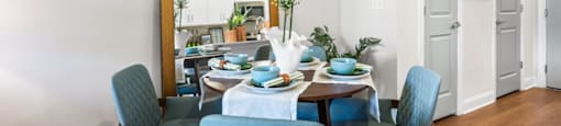 A dining room with a table set for four.