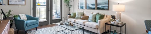 A living room with a blue chair and a white couch.