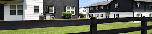 a black and white fence separates two rows of houses