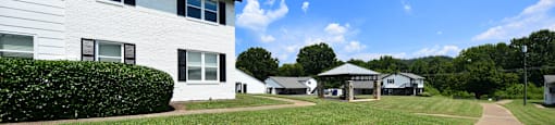 a large white building with a grassy area in front of it