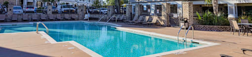 A large swimming pool in front of apartment buildings.