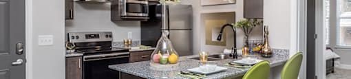 a kitchen with a bar and green stools