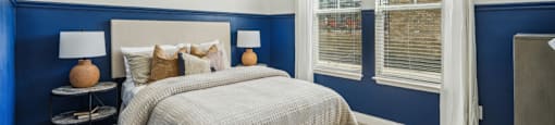a blue and white bedroom with a bed and a ceiling fan