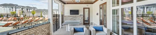 a living room with couches and chairs and a balcony
