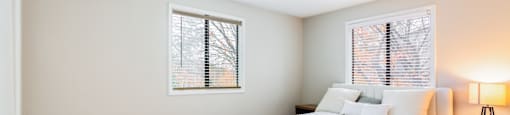 A bedroom with a bed, nightstand, and window.