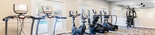 A spacious gym with treadmills, elliptical machines, and other exercise equipment.
