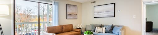 A living room with a couch, coffee table, and pictures on the wall.