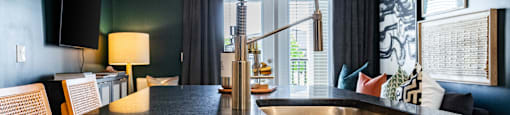 A modern kitchen with a black countertop and a sink. at Evolve Waterford Apartments in Belville, NC