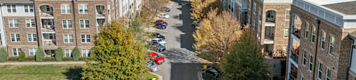 A parking lot is surrounded by apartment buildings.
