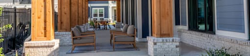 A wooden covered patio with a table and chairs.