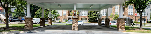 A covered parking area in front of a building.