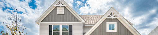 a white house with a garage door and a lawn