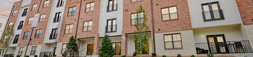 A modern apartment building with a mix of brick and white exterior walls at 2918 North Winstead Commons in Greensboro, NC.