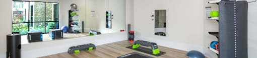 A gym with exercise equipment and a mirror on the wall at Liam at Hays Farm in Huntsville, Alabama