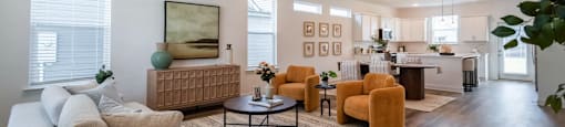 A living room with a couch, chairs, and a ceiling fan.