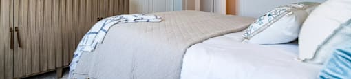 A bedroom with a large bed and a painting on the wall.