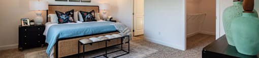 A bedroom with a bed, nightstands, and a ceiling fan.