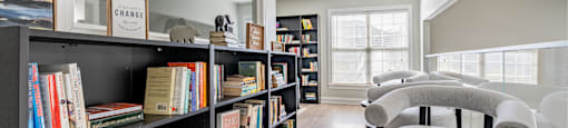 a living room with a bookshelf filled with books    and chairs