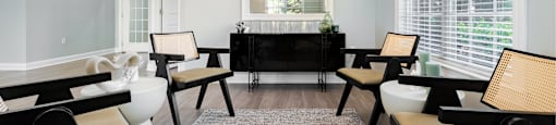 a living room with white walls and a black table and chairs