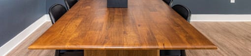 a conference room with a wooden table and chairs and pictures on the wall
