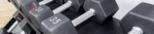 a large pile of dumbbells in a gym