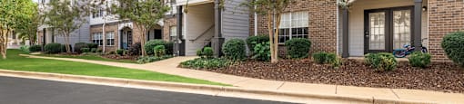 A row of townhouses with a tree in front of the first one.