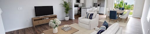 a living room with white furniture and a tv