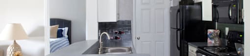 A kitchen with black appliances and a white island at 1287 Shoals apartments in Athens, GA.