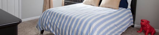 A bedroom with a bed and nightstand at 1287 Shoals apartments in Athens, GA.