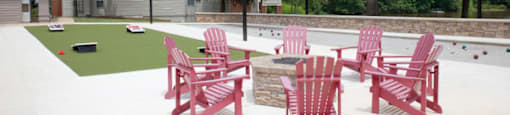 A set of red chairs are arranged on a patio outside in front of cornhole boards at 1287 Shoals in Athens, GA.