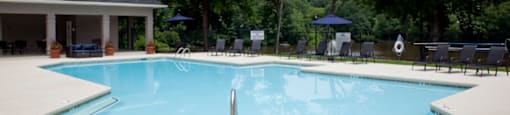 A large outdoor swimming pool with a pavilion in the background at 1287 Shoals apartments in Athens, GA.