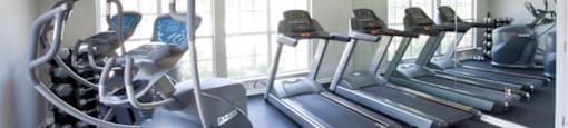 A gym at 1287 Shoals apartments in Athens, GA, with treadmills and exercise bikes.
