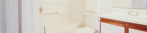 a white bathroom with a toilet and a sink