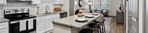A modern kitchen with a granite countertop and stainless steel appliances.