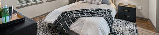 A bedroom with a bed, nightstands, and a ceiling fan.