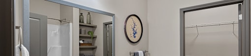 A bathroom with a sink, mirror, toilet, and shower.