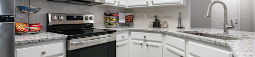 A kitchen with white cabinets and appliances.