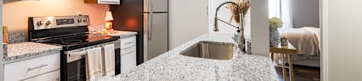 A kitchen with a granite countertop and white cabinets.