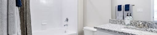 A bathroom with a toilet, sink, and bathtub.