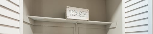 Two white washing machines in a small laundry room.