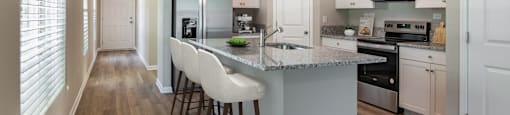 a kitchen with white cabinets and a marble counter top