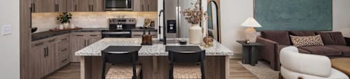 A modern kitchen with a bar stool and a countertop at Liam at Hays Farm in Huntsville, Alabama