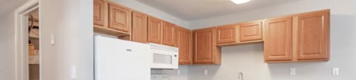 a kitchen with white appliances and wooden cabinets