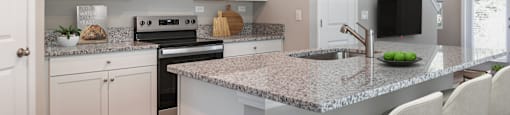 a kitchen with white cabinets and a granite counter top